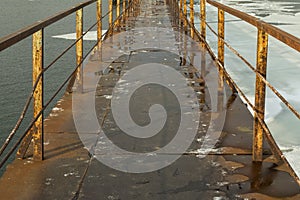 Frozen old pier at river side in winter time.