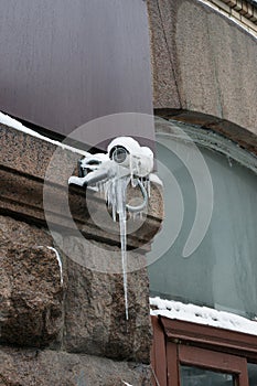 Frozen outdoor security camera on a building covered with ice