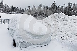 Frozen parked car, covered in a lot of snow