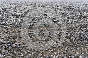 Frozen plowed agricultural field covered with frost