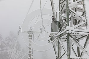 Frozen power line pylons. Hoarfrost on high voltage cables and pylons. Winter in the mountains