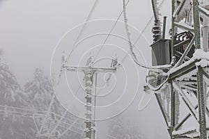 Frozen power line pylons. Hoarfrost on high voltage cables and pylons. Winter in the mountains