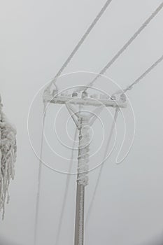 Frozen power line pylons. Hoarfrost on high voltage cables and pylons. Winter in the mountains