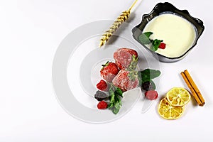 Frozen raspberry, blackberry, strawberries, yoghurt plate, mint leaves, slices of lemon, apple, wheat, on a white background top v