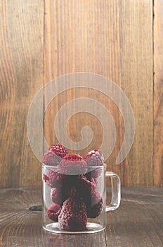 frozen raspberry used in a glass cup/frozen raspberry used in a glass cup on a wooden background