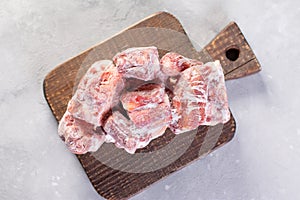 Frozen raw beef bones on a cutting board