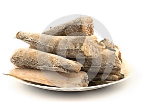 Frozen raw fish hake, pollock on the plate isolated on white bac