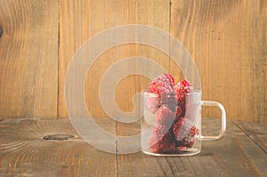 frozen red raspberry in a glass cup /frozen red raspberry in a glass cup on a wooden background, copy space