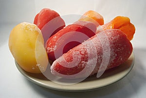 Frozen red yellow bell peppers paprika on a plate white background