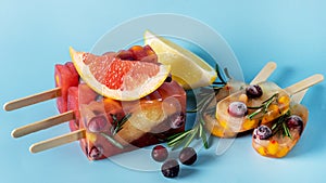 Frozen Refreshing Summer Cocktail Popsicles Recipe Cold Sweet Berry and Citrus Tea with Rosemary Blue Background Banner