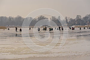 Frozen river, bent and icy anglers