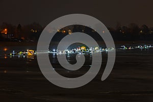 Frozen river, night and ice anglers