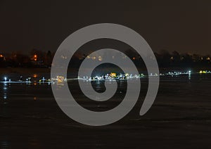 Frozen river, night and ice anglers