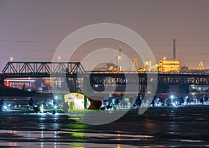 Frozen river, night and ice anglers