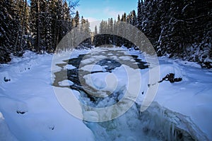 Frozen river while Roadtripping in The majestuous rockies between Jasper and Alberta on Alberta Highway 93, Alberta, Canada photo