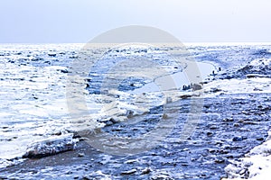 Frozen river sea on dike snow ice floes black ice