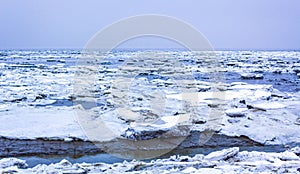 Frozen river sea on dike snow ice floes black ice