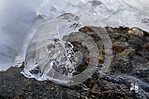 Frozen river with stream of water covered by snow and ice.