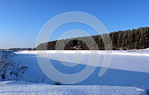 Frozen river under a thick layer of white snow