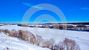 Frozen river winter covered with snow. Beautiful lake landscape in ice. Clear blue sky with clouds.