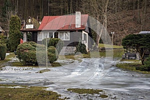 Frozen road to cottage with red roof