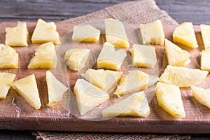 Frozen slices of frozen pineapple on a cutting board