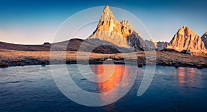 Frozen small lake at the foot of Ra Gusela mountain. Fantastic sunrise in Dolomite Alps