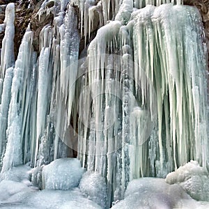 Frozen small mountain waterfall close up