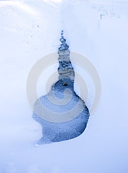 A frozen snowy pond shaped like a tear or a sperm