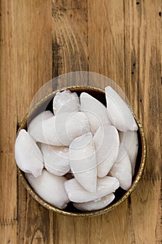 Frozen squids in dish on brown background