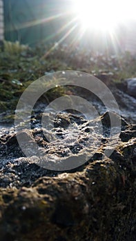 Frozen stone under sun rays