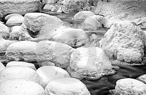 Frozen stream in winter forest.