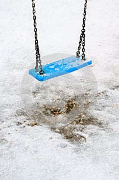 Frozen swing on children playground in winter