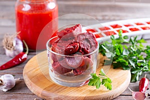 Frozen tomato paste cubes on a cutting board. Life hacks, simple way to store vegetables