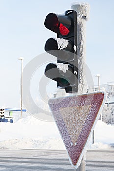 Frozen traffic light at winter showing red