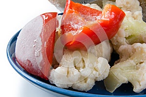 Frozen vegetables on the blue plate closeup