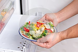 Frozen vegetables: broccoli, corn, pea, cauliflower, peppers, green beans on plate in the freezer