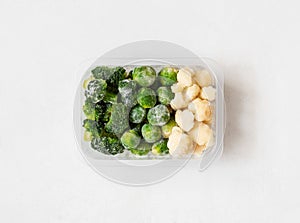 Frozen vegetables. Cabbage set. Broccoli, brussels sprouts and cauliflower in a container on a white background. Top view, flat