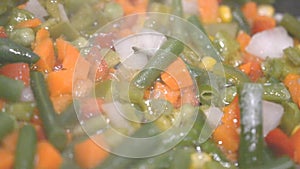 Frozen vegetables cooking in a frying pan hd footage slow motion