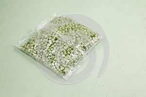 Frozen vegetables. Green peas in transparent bag. Selective focus, copy space