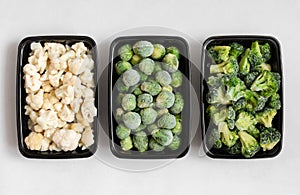 Frozen vegetables in plastic containers on a white background. Cabbage mix. Broccoli, brussels sprouts, cauliflower. Top view,