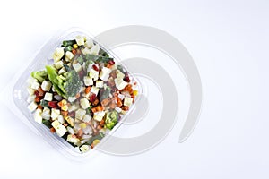 Frozen vegetables in transparent dishes on a light background.