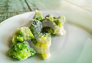 Frozen veggies frosted broccoli icing outside freezer fridge