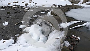 Frozen water cascade with icicles thawing and flowing