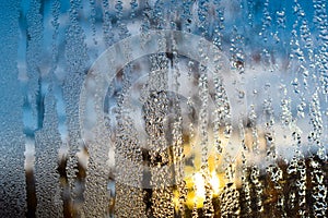 Frozen water drops on the window glass on a winter morning.