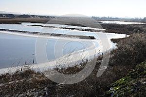 Frozen water, patterns of snow in small lakes.