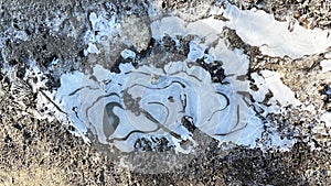 Frozen water in puddles in the mountains on the road photo