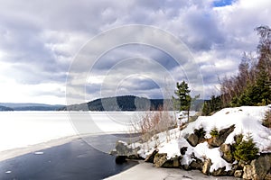 Frozen water reservoir in the area of Josefuv Dul at the dam, Izera Mountains, Czech Republic, Europe. Dramatic clouds ot the sky.