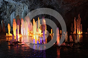 Frozen water Stalagmite in deep marble cave, Russia