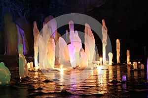 Frozen water Stalagmite in deep marble cave, Russia